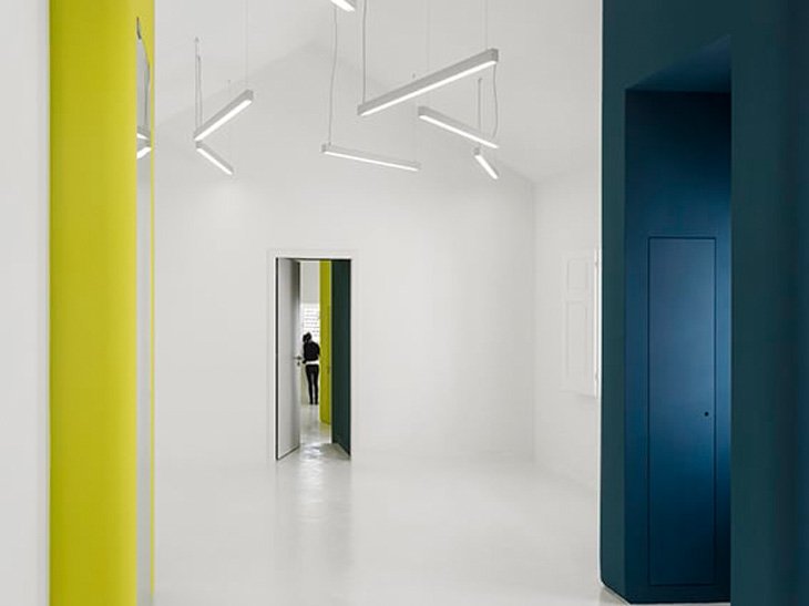 Vista estancia interior con paredes en blanco, amarillo y azul en Transforma Estudios